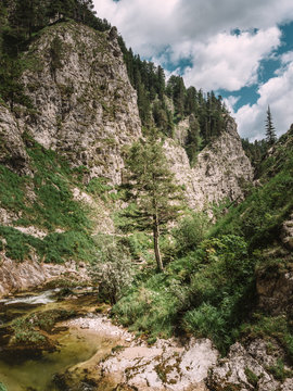 View of river passing through mountain against cloudy sky