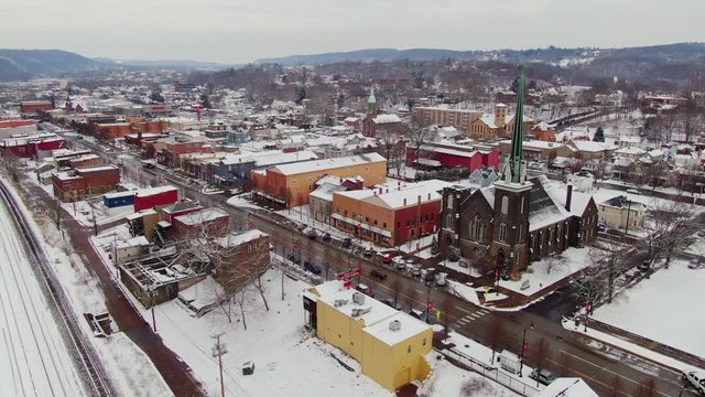 A slow aerial orbit around the business district of a typical Pennsylvanian river town at Wintertime. Pittsburgh suburbs.  	