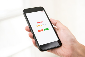 Mobile phone user giving feedback of the application by rating with stars