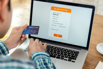 Young man filling credit card information making payment online