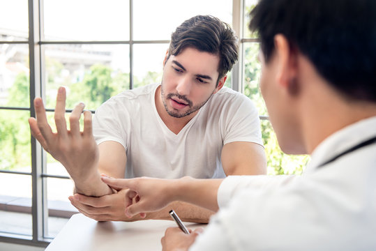 Male Patient Consulting With Doctor Wrist Muscule Pain From Exercise