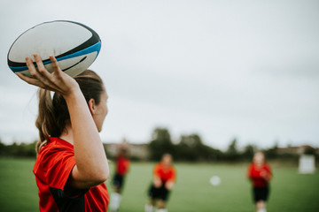 Female rugby player holding a ball - Powered by Adobe