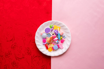 candy cane on white plate with pink and red tablecloth texture background, Valentine's day holiday celebration.