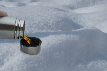 thermos with tea on snow
