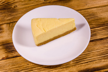 White plate with cheesecake New York on wooden table