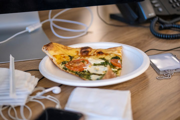 Pizza on a desk at an office
