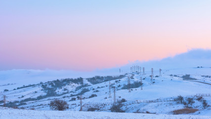 Power poles in a snowy field, winter landscape