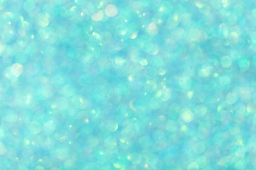 Obraz na płótnie Canvas Blurred shiny turquoise background with sparkling lights.