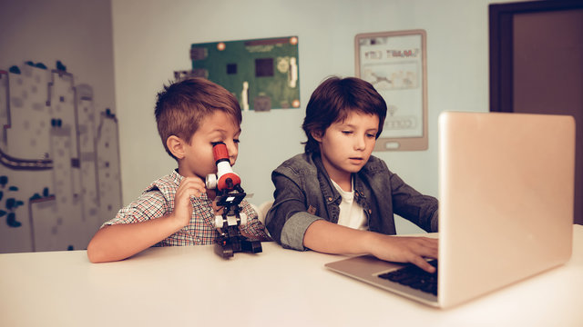 Sitting Boys Using Laptop and Microscope at Home. - Powered by Adobe