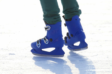 legs in blue skating on the ice rink