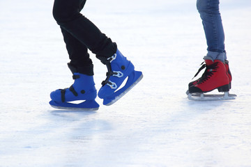 feet of different people skating on the ice rink