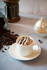 cup of coffee with whipped cream and beans