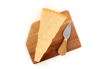 A piece of aged Parmesan cheese on a wooden cutting board with a cheese knife, shot from above on a...