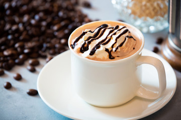 cup of coffee with whipped cream and beans