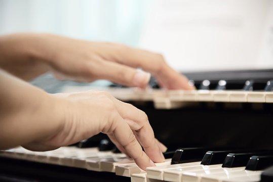 Woman hand play electone keyboard - people with music concept