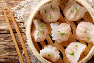 Chinese prawn dumplings dim sum placed in a bamboo steamer. horizontal top view © FomaA