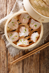 Dim Sum in bamboo steamer, Chinese cuisine. Closeup rustic. Vertical top view