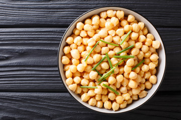 Fresh boiled organic chickpeas with green onions close-up in a bowl. horizontal top view