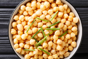 Healthy boiled chickpeas with green onions close-up in a bowl. Horizontal top view