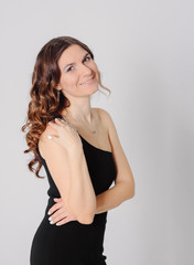 Fototapeta premium Young charming brunette woman with curly hair style in evening e