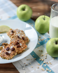 Homemade oat pancakes with vegan yogurt, raisins and walnut on the wooden table with blue fabric in the box. 