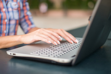 Close up shot of female hands typing on a laptop keyboard