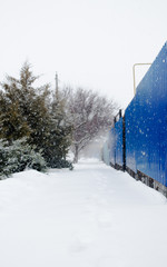Winter background in snow day with blue fence