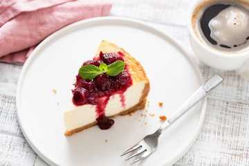 Cheesecake With Cherry Sauce On Plate On Wooden Table And Cup Of Coffee. Top View