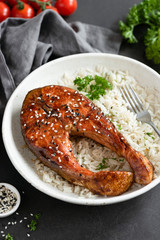 Grilled salmon steak with rice and sesame seeds on plate. Asian food