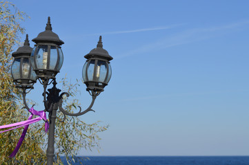 Fototapeta na wymiar Lantern with water surface background on seashore on Kyiv Sea, autumn