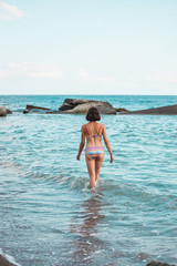 The girl goes into the sea water.