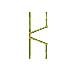 Capital letter K made of green bamboo poles on white background.