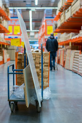 construction cart in the building store. Carts loaded with boards. shop of building materials. Racks with boards, wood and building material. loaded cart in a hardware store