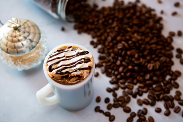 cup of coffee with whipped cream and beans