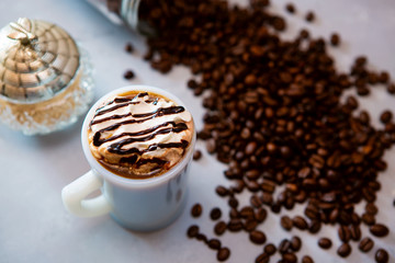 cup of coffee with whipped cream and beans
