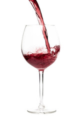 Beautiful splash of red wine in a glass on white background.