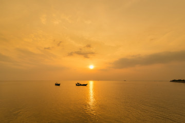 Beautiful sunrise on the beach and silhouette of fishing boat.Thailand.