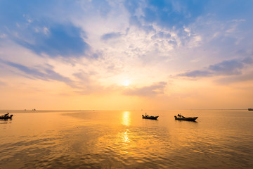 Naklejka na ściany i meble Beautiful sunrise on the beach and silhouette of fishing boat.Thailand.