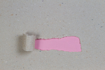 Brown package paper torn to reveal pink background with copy space