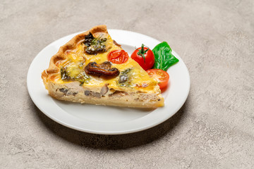Slice of traditonal homemade spinach chicken quiche tart or pie on plate