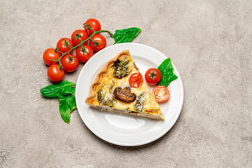 Slice of traditonal homemade spinach chicken quiche tart or pie on plate