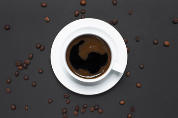 Obraz na płótnie Canvas Flat lay cup of black coffee and coffee beans on gray dark background top view copy space. Minimalistic food concept, morning breakfast, time to work, hot drink, coffee background