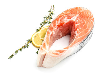 Piece of fresh salmon with lemon and thyme on white background