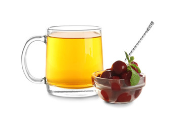 Cup of hot tea and bowl with berries on white background