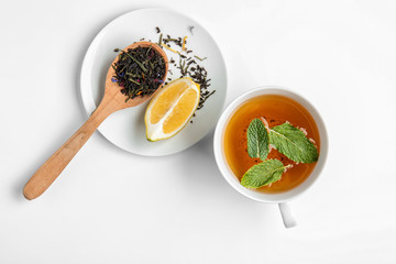 Composition with cup of hot tea on white background