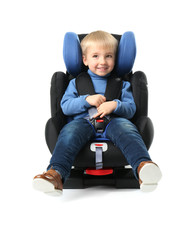 Baby boy buckled in car seat on white background