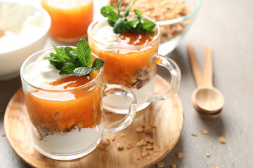 Cups of tasty yogurt with jam on table