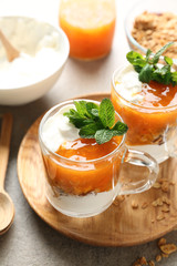 Cups of tasty yogurt with jam on table