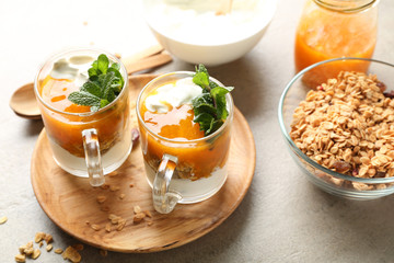 Cups of tasty yogurt with jam on table