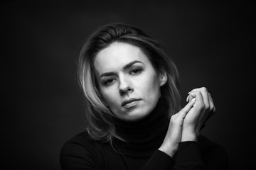 Fototapeta premium Dramatic black and white portrait of a beautiful woman on a dark background